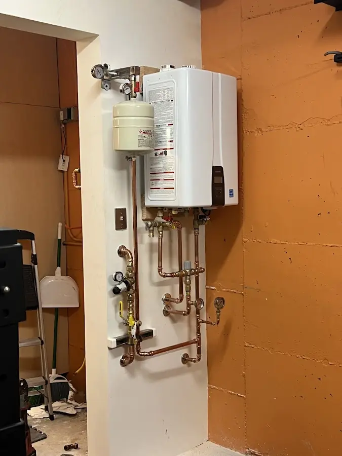 Plumbing technician inspecting water heater connections in Annville